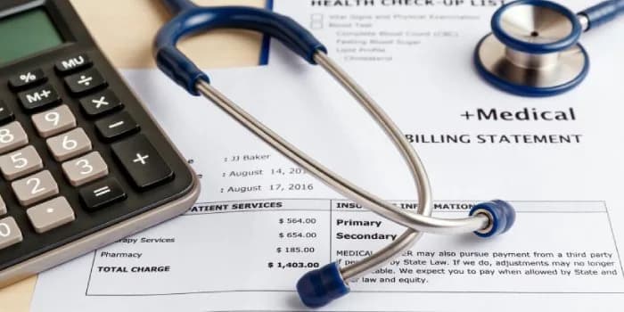 A calculator and stethoscope on a printed patient billing statement