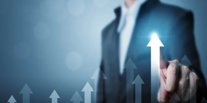 A hand touching a glowing upward arrow rising above rows of smaller arrows