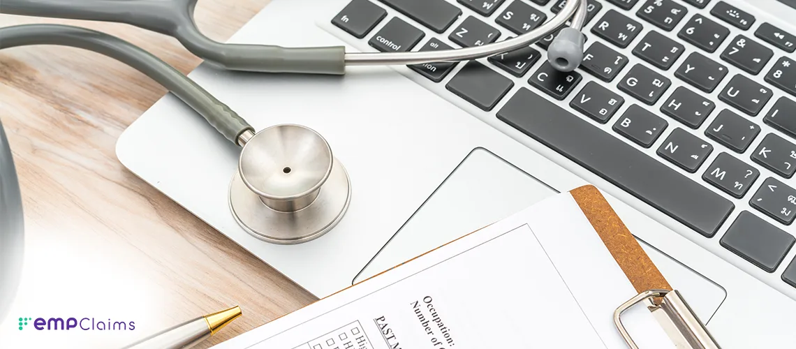 A stethoscope resting on a laptop keyboard beside a clipboard
