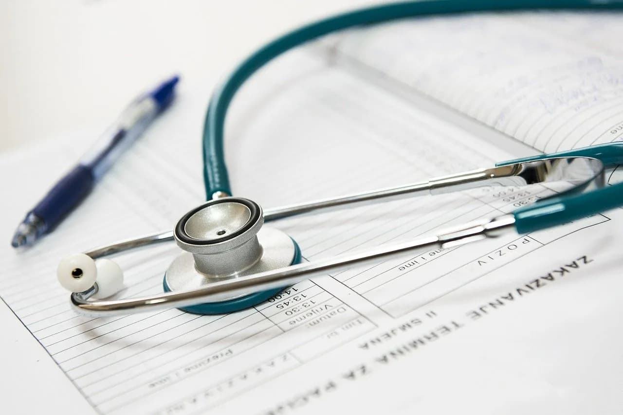 A stethoscope and pen resting on a printed medical claim form