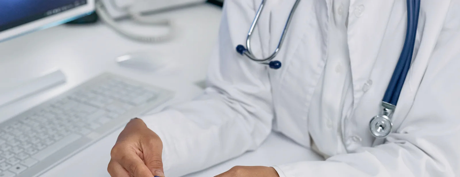 A clinician entering notes on a laptop