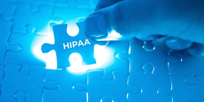 A hand fitting a puzzle piece labelled HIPAA into place